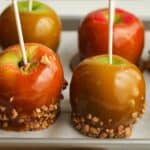 Side shot of caramel apples with toppings.