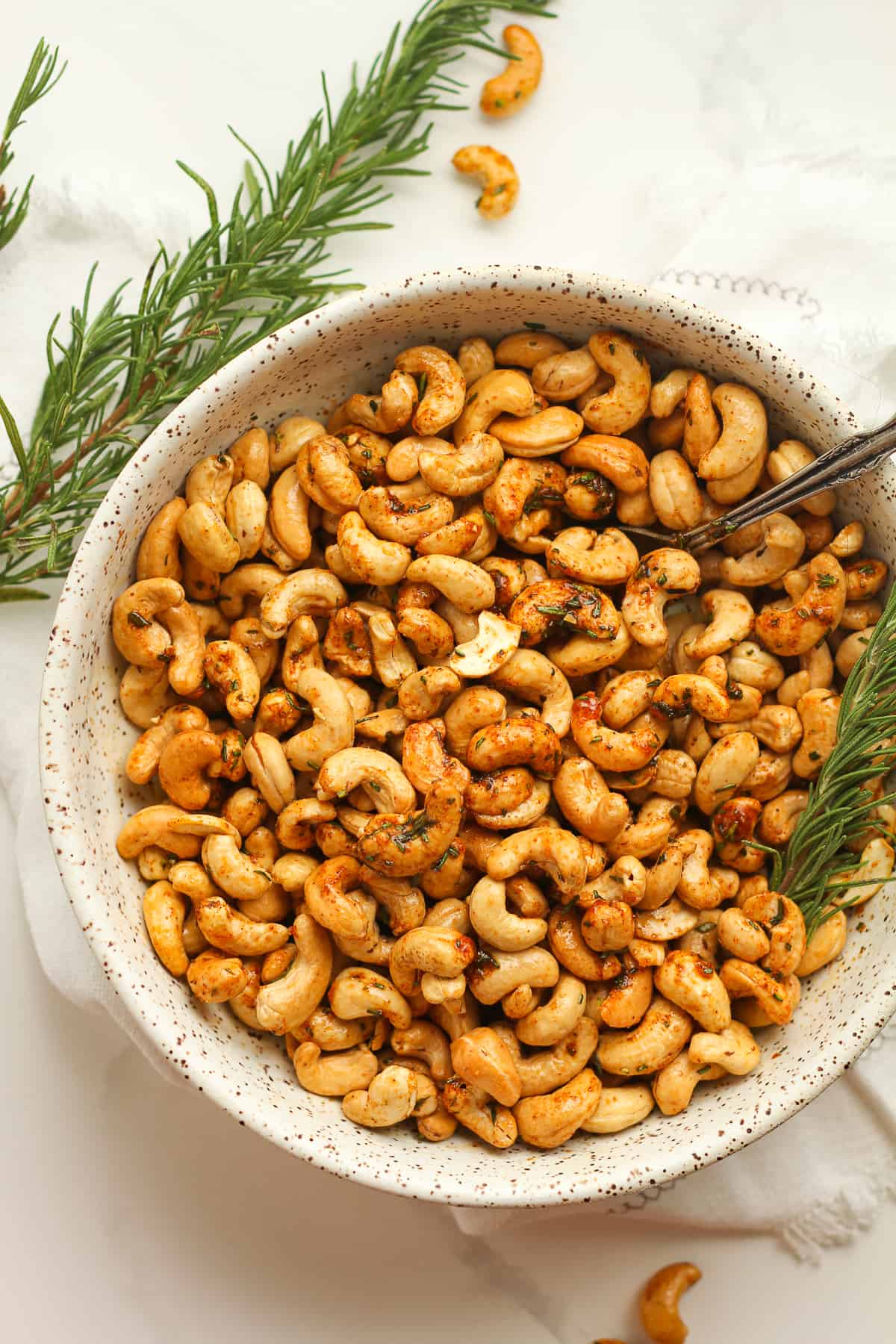 Some rosemary cashews with rosemary sprigs.