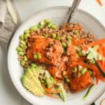 A bowl of salmon over farro with veggies.