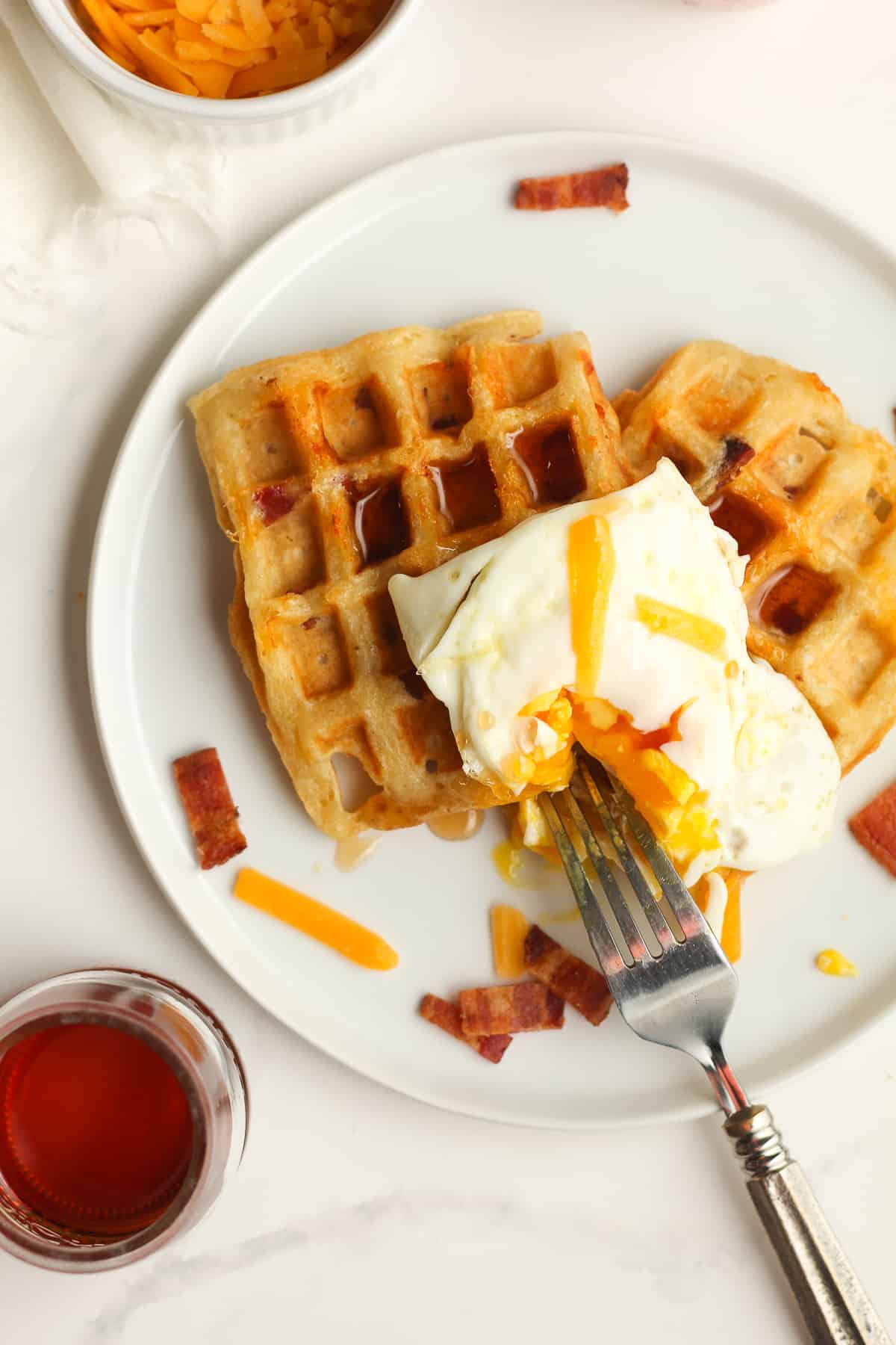 A plate of waffles with an egg on top.