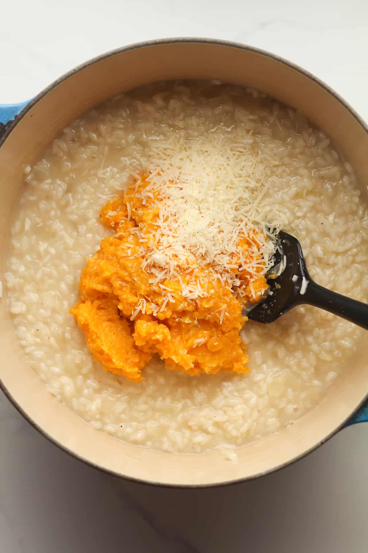 A stockpot of risotto with the pureed squash on top.