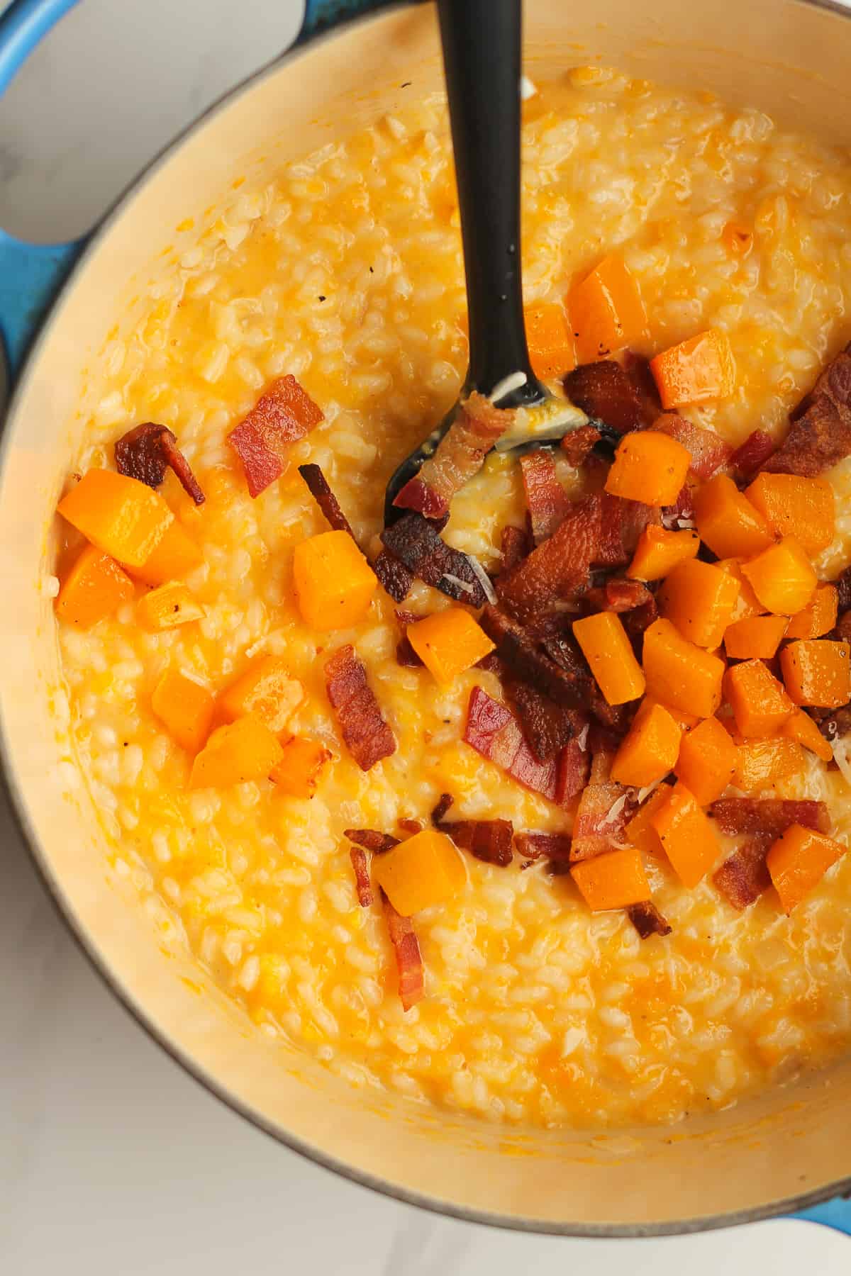 Closeup on a pot of butternut squash risotto with bacon.