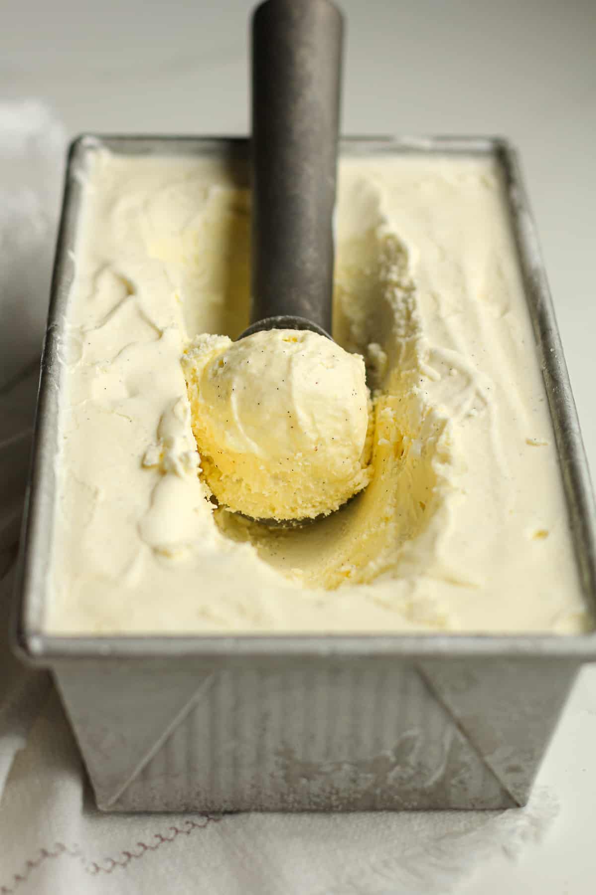 A scoop of vanilla bean ice cream in a pan.