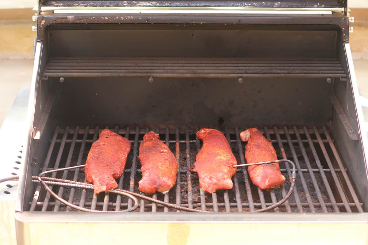 Four pork tenderloins on smoker.