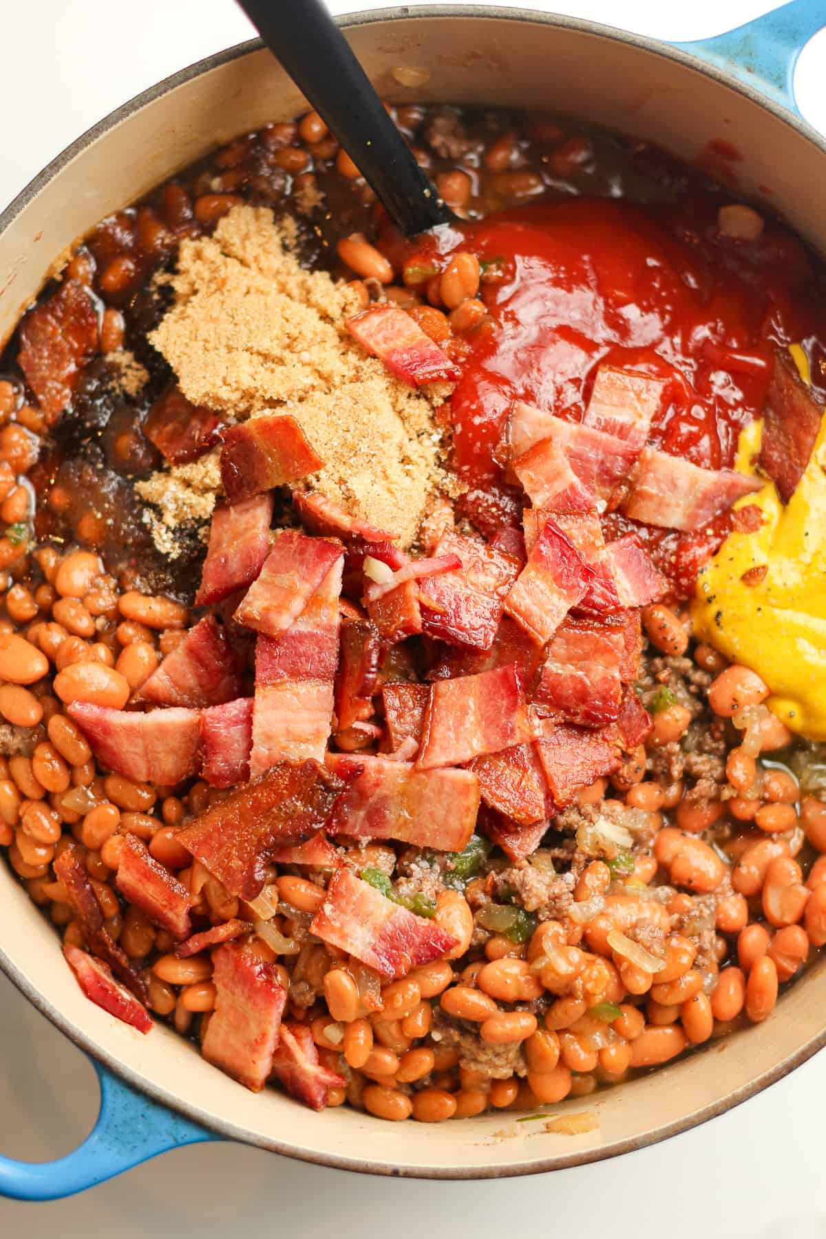 The pot with the beans plus ingredients all layered on top.