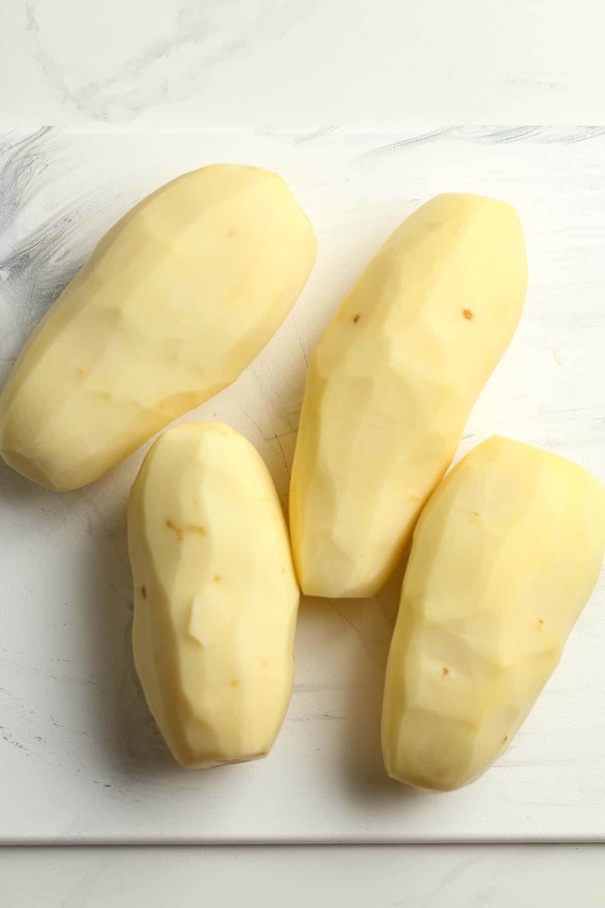 Four peeled potatoes.