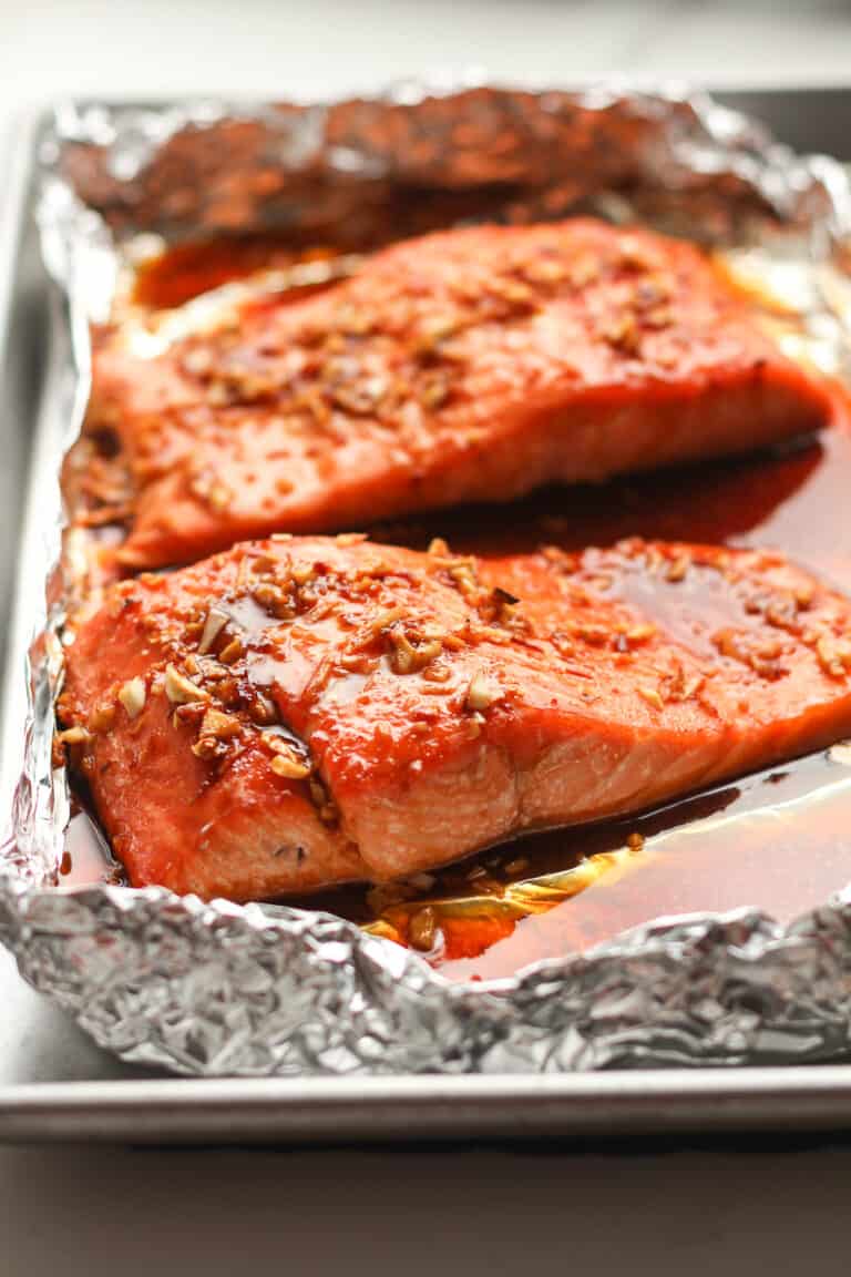 Side shot of two large pieces of baked salmon.