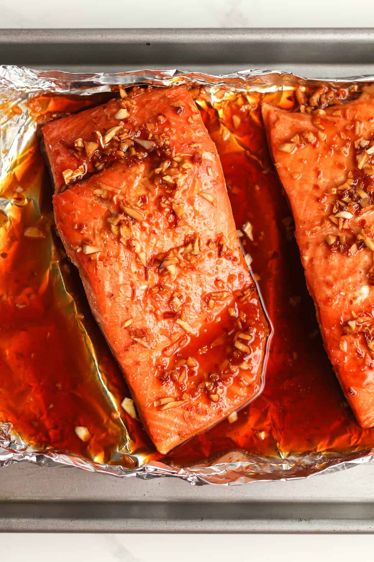 Overhead shot of a chunk of baked salmon with marinade.