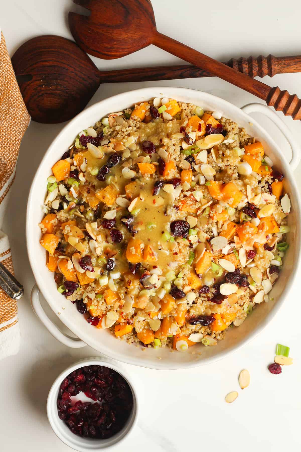 A bowl of the quinoa salad with salad tongs.