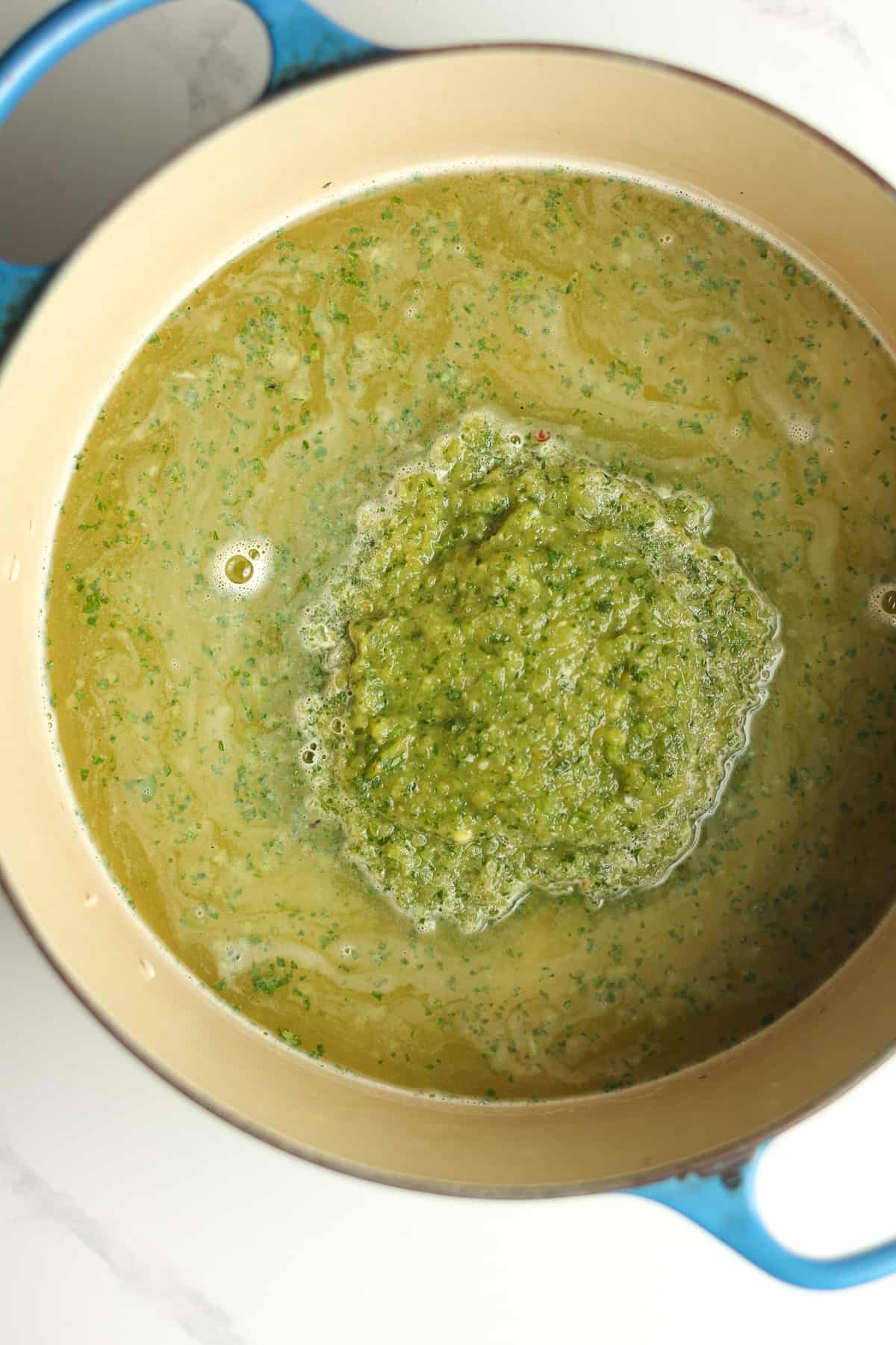 A stock pot of the rice with the green mixture poured on top.