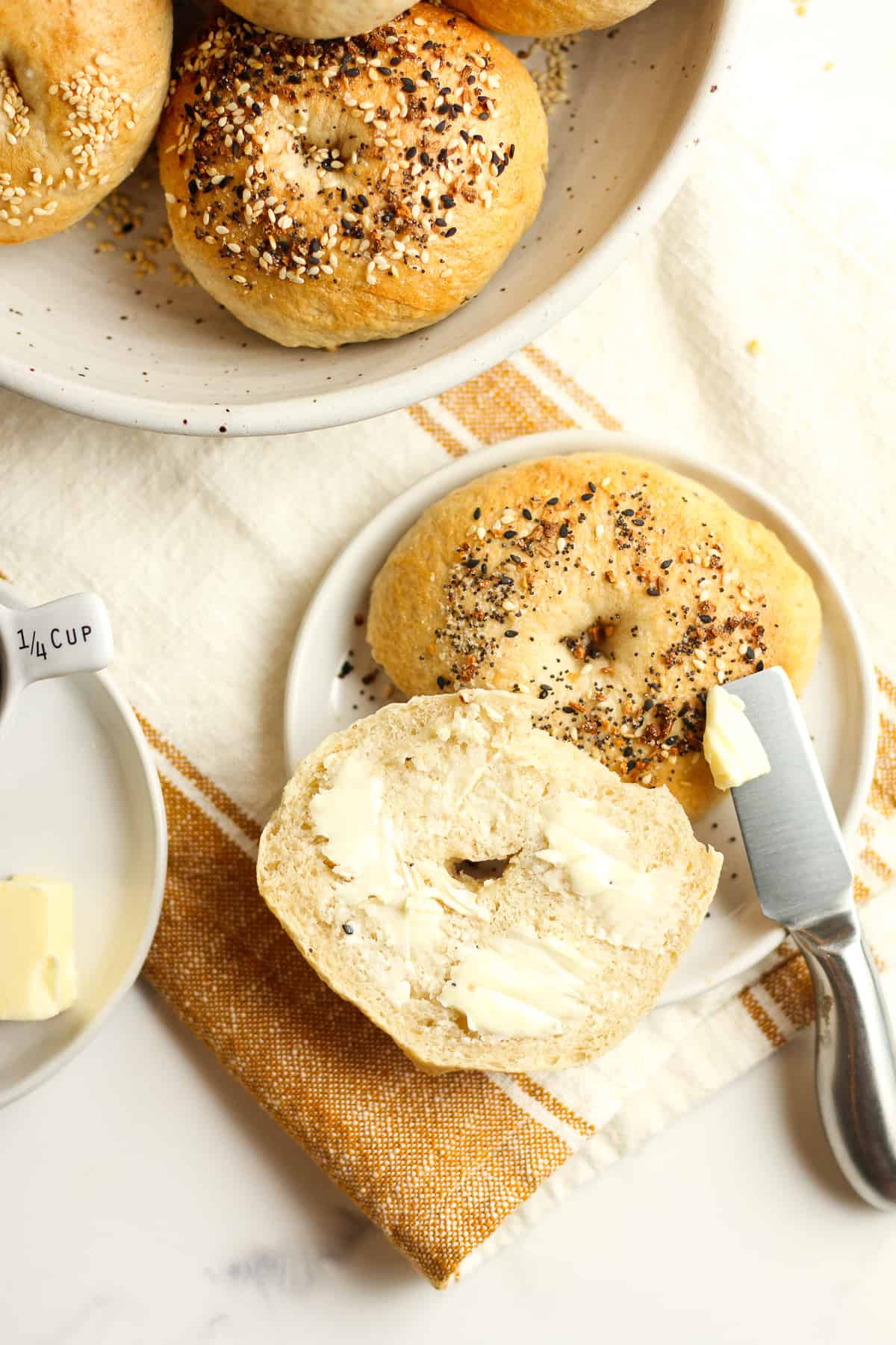A small plate with a sliced bagel with butter.