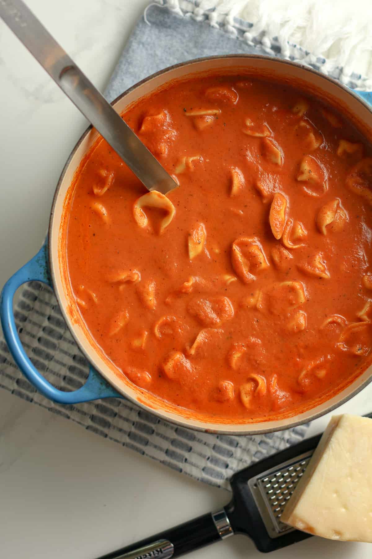 A stock pot of tomato tortellini soup.