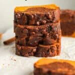 A stack of four slices of chocolate pumpkin bread.