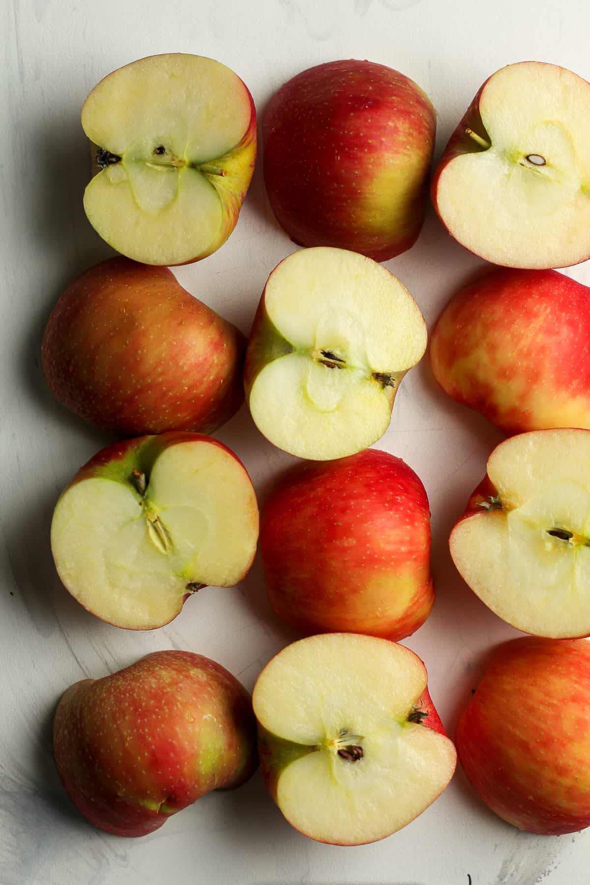 Halved apples on a white surface.