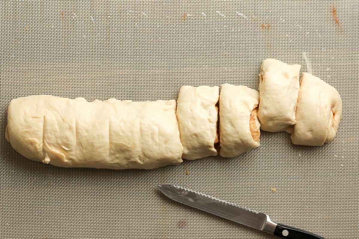 The rolled cinnamon dough cut into nine slices.