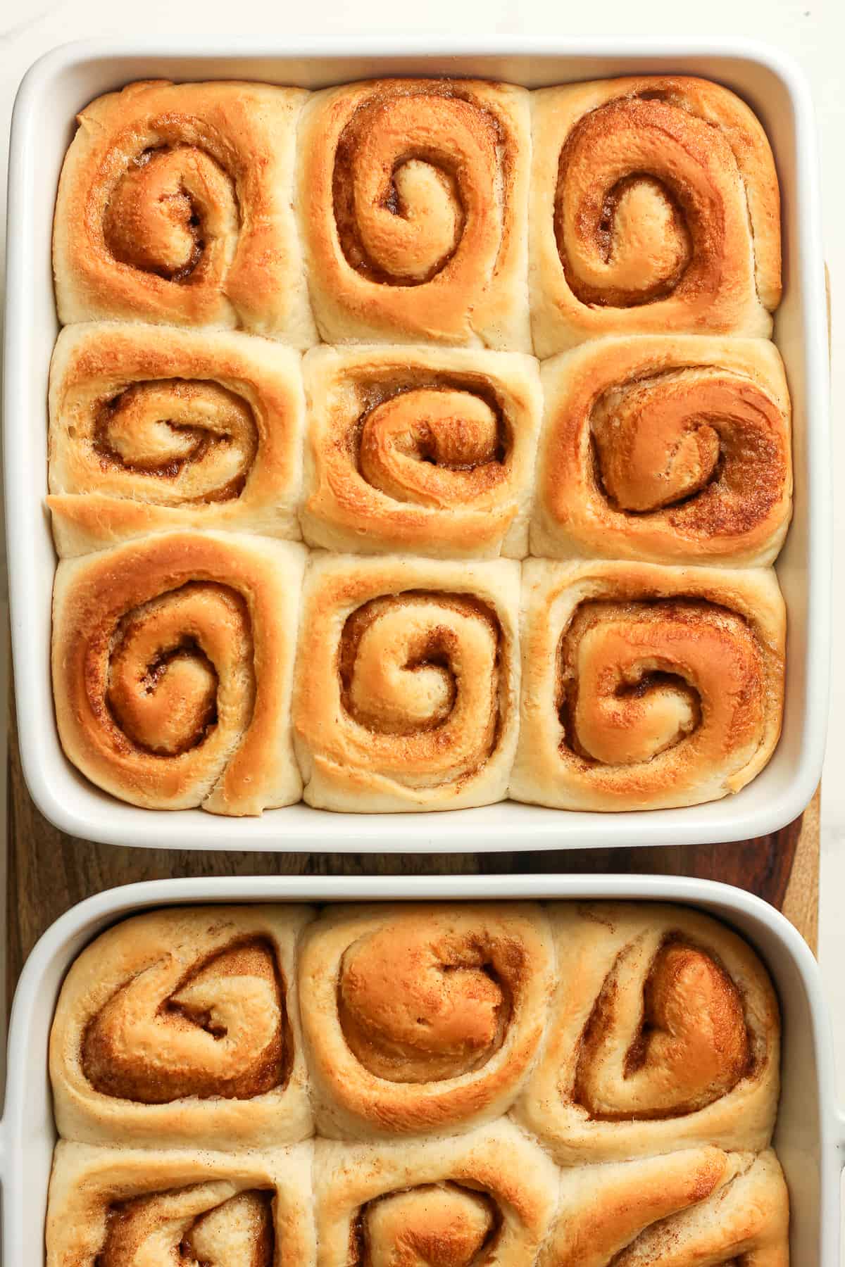 Two dishes of cinnamon rolls.