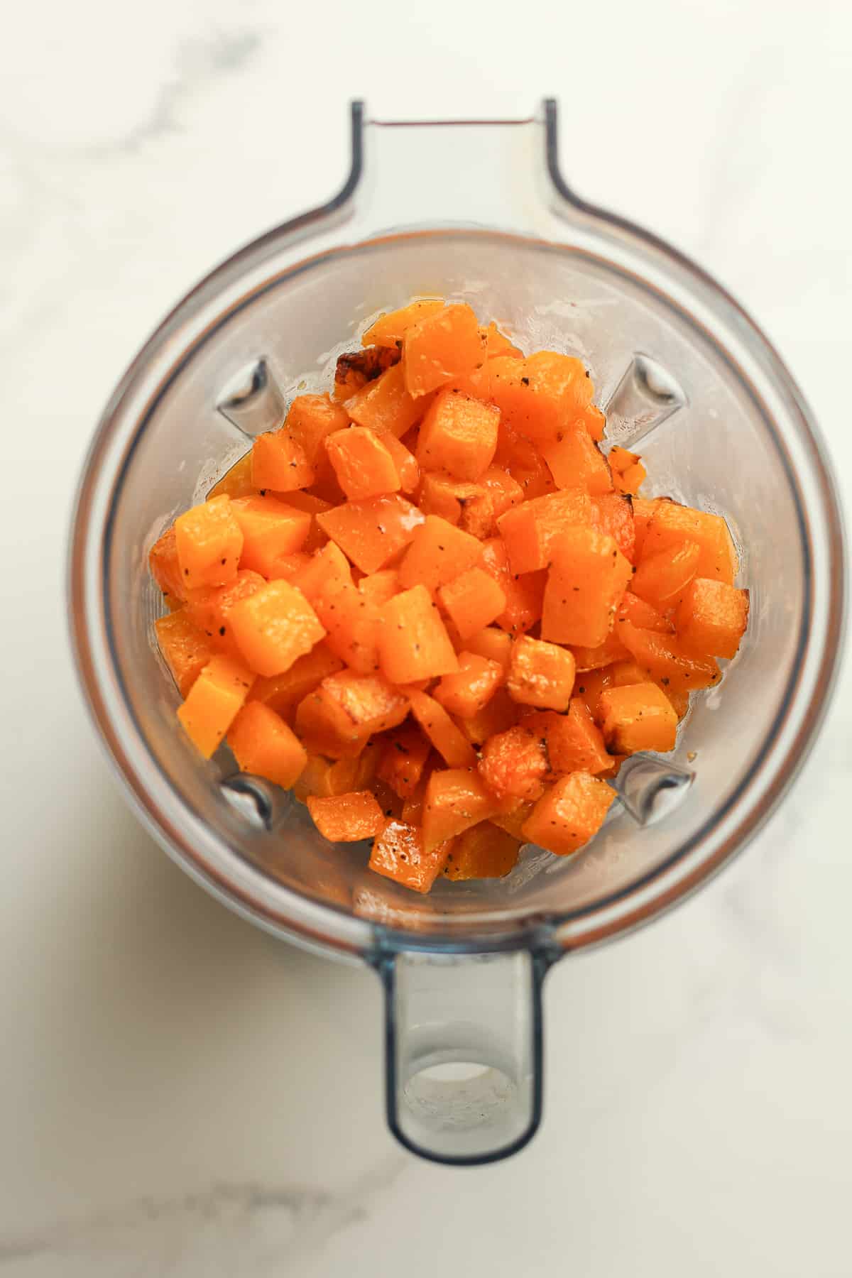 A blender with the roasted and cubed butternut squash.