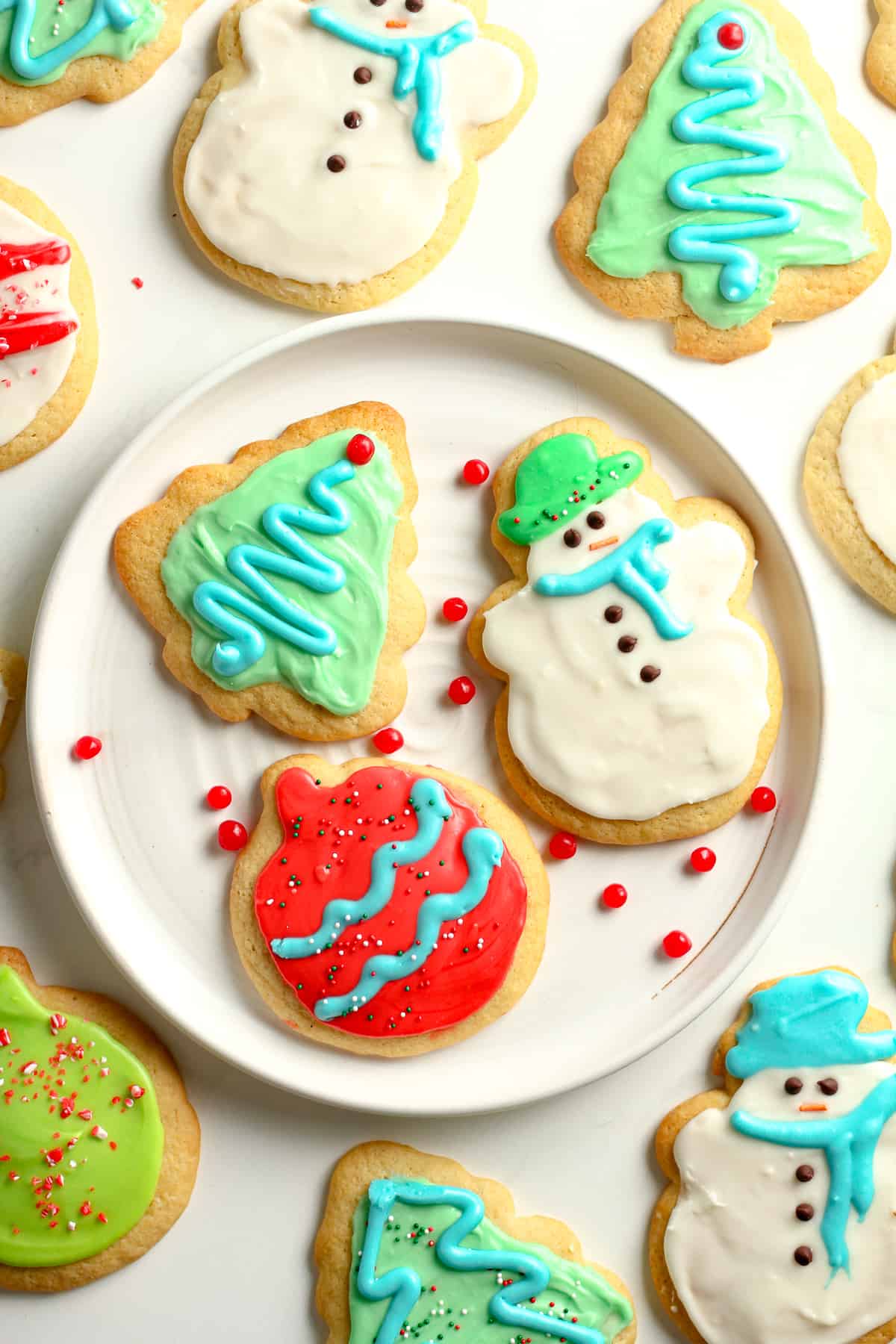 A plate of decorated cookies with other cookies around it.