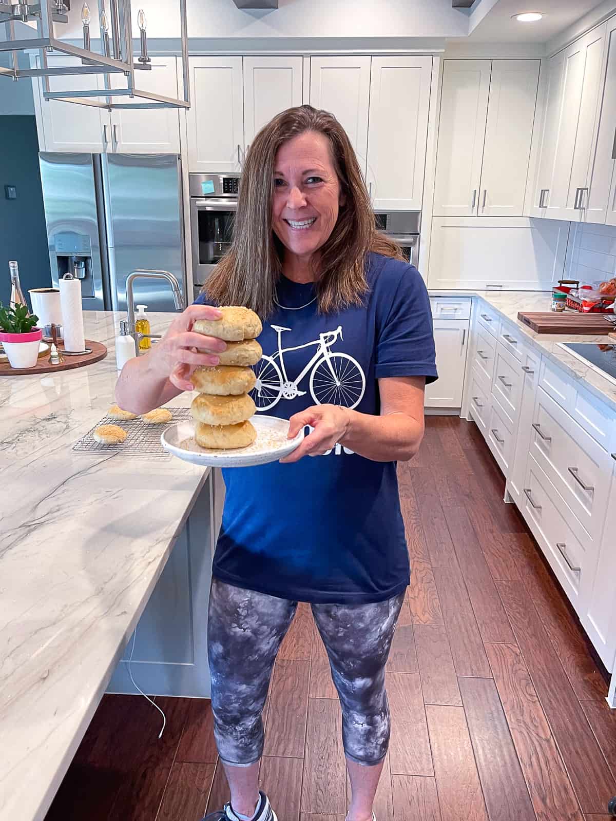 Me holding a plate of sourdough bagels.