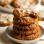 A stack of oatmeal iced cookies on a plate.