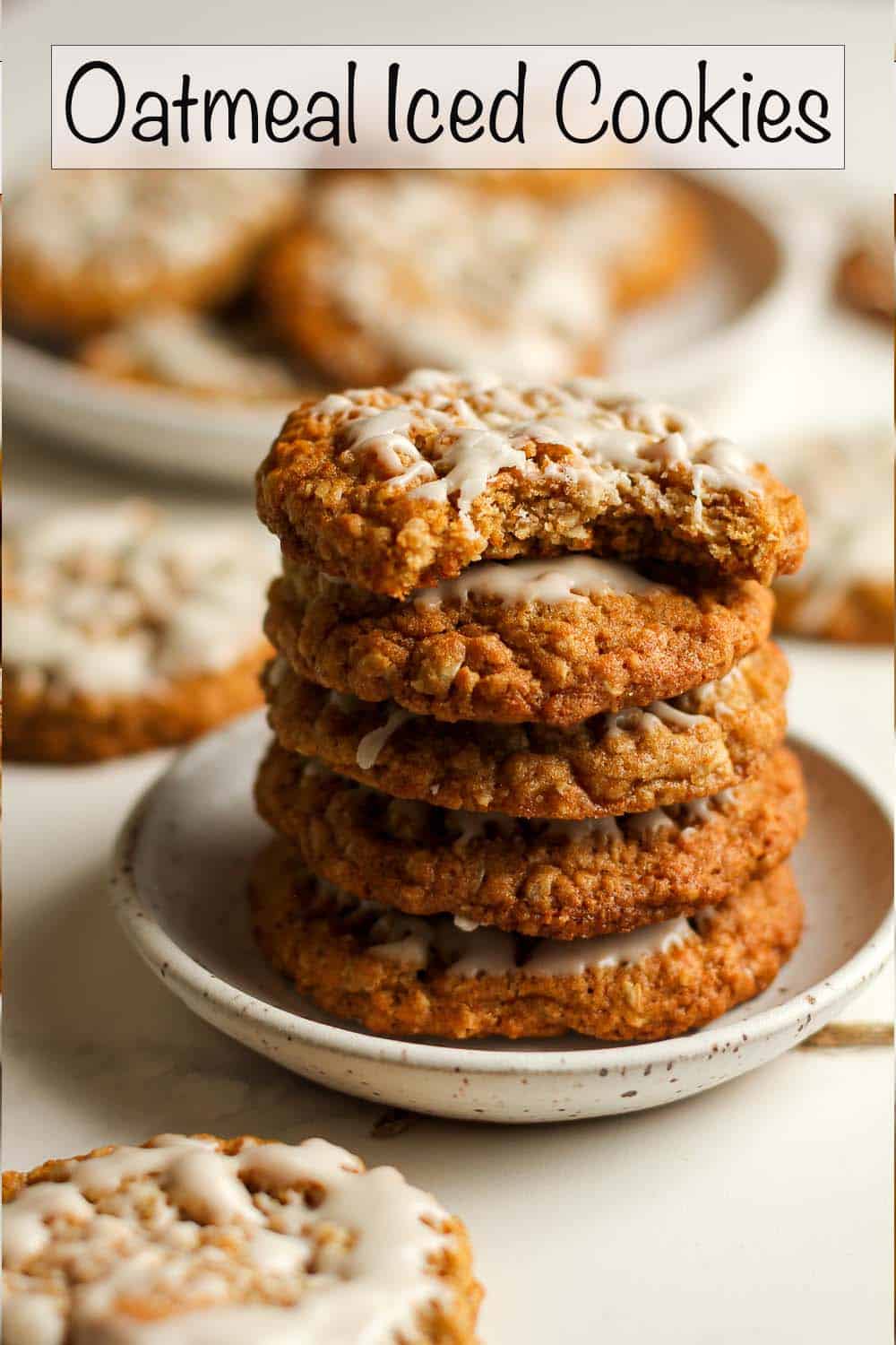 A stack of oatmeal iced cookies on a plate.