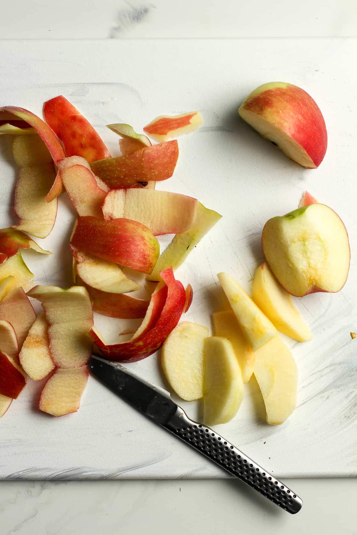 A cutting board with the apple peeling process.