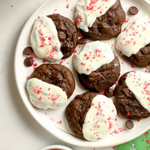 Overhead shot of a white plate of peppermint mocha cookies, next to a green tea towel.