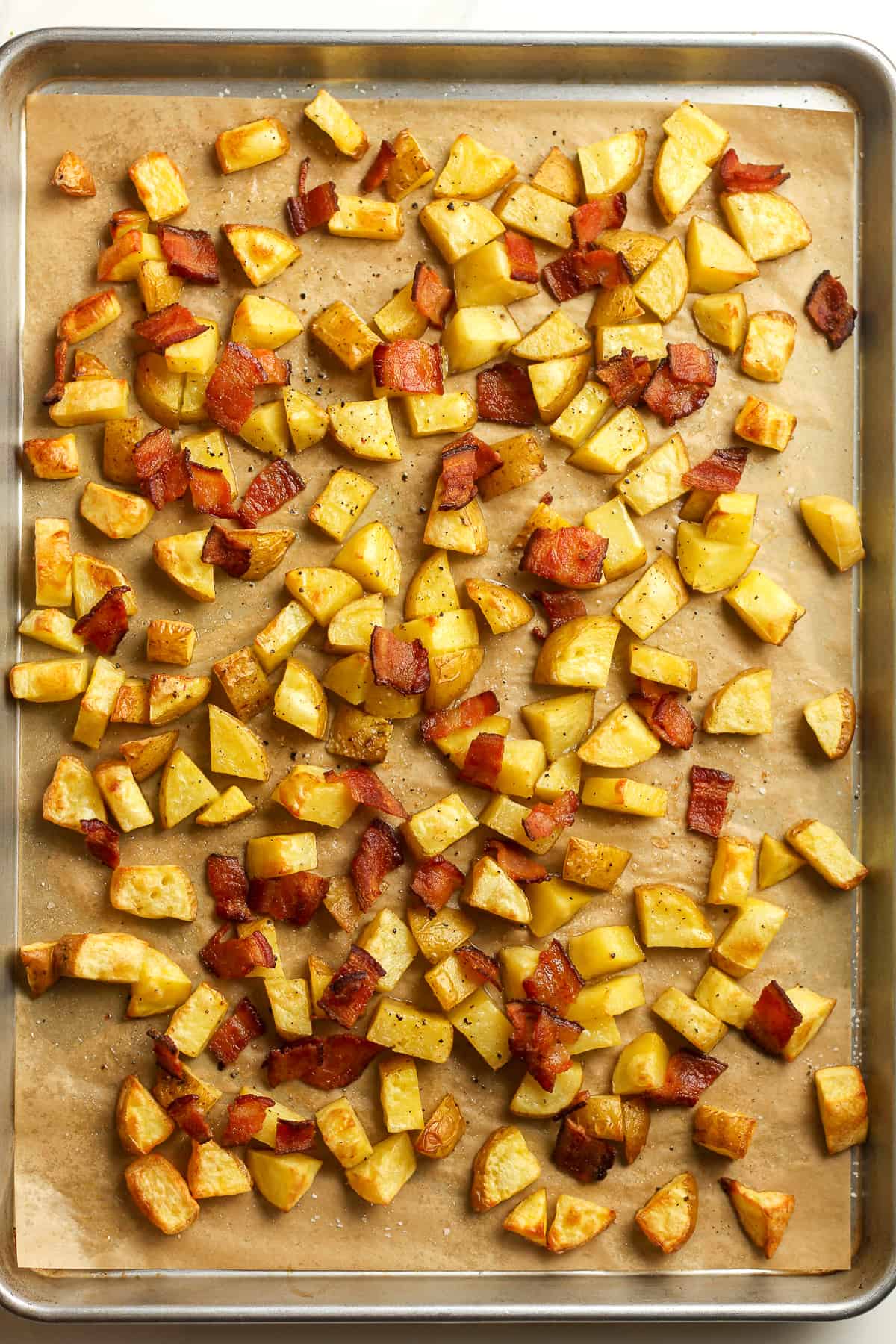 A pan of roasted potatoes and chopped bacon.