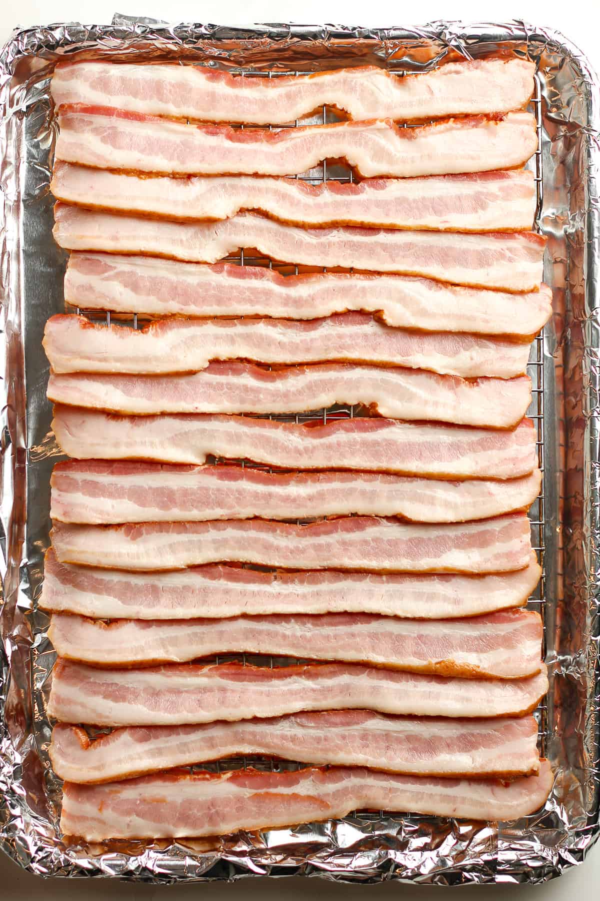 A sheet pan of raw bacon.