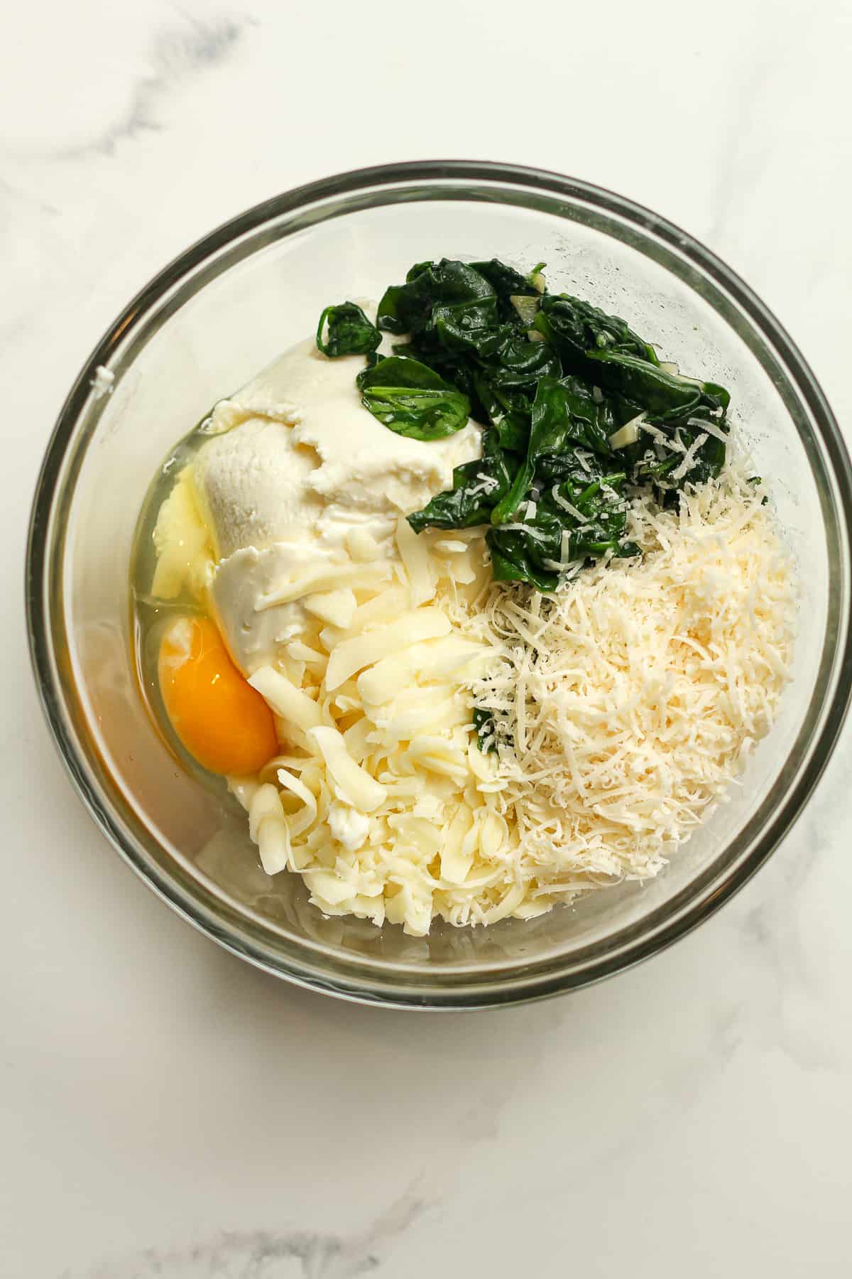A bowl of the ingredients of spinach layer before combining.
