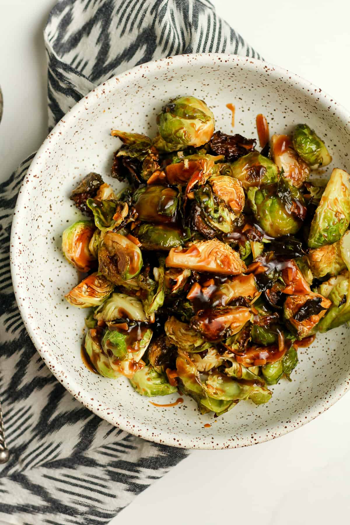 A bowl of the cooked Brussels sprouts with teriyaki sauce.