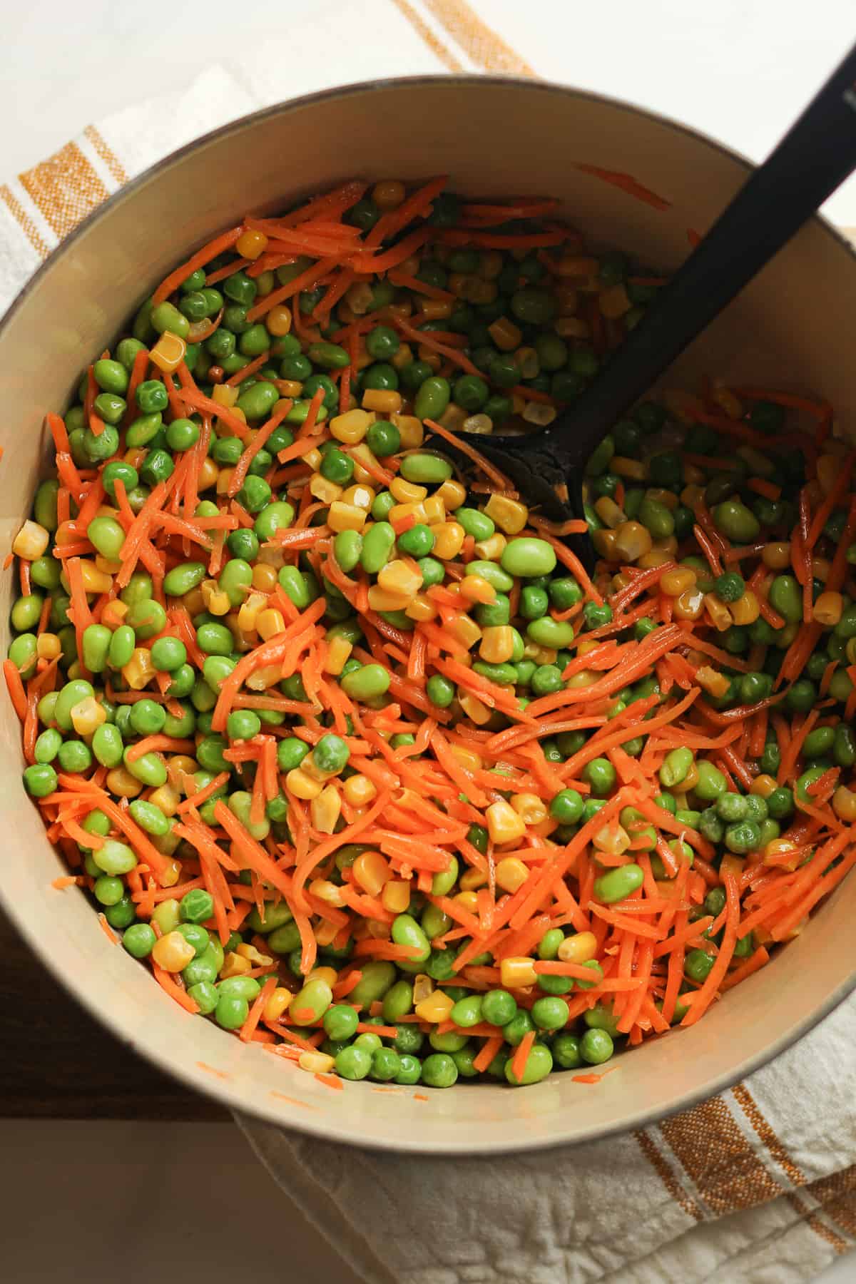 A stock pot of the frozen veggies and shredded carrots.