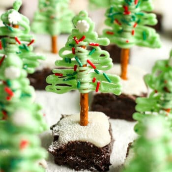 A side view of several brownie bites with almond bark Christmas trees.