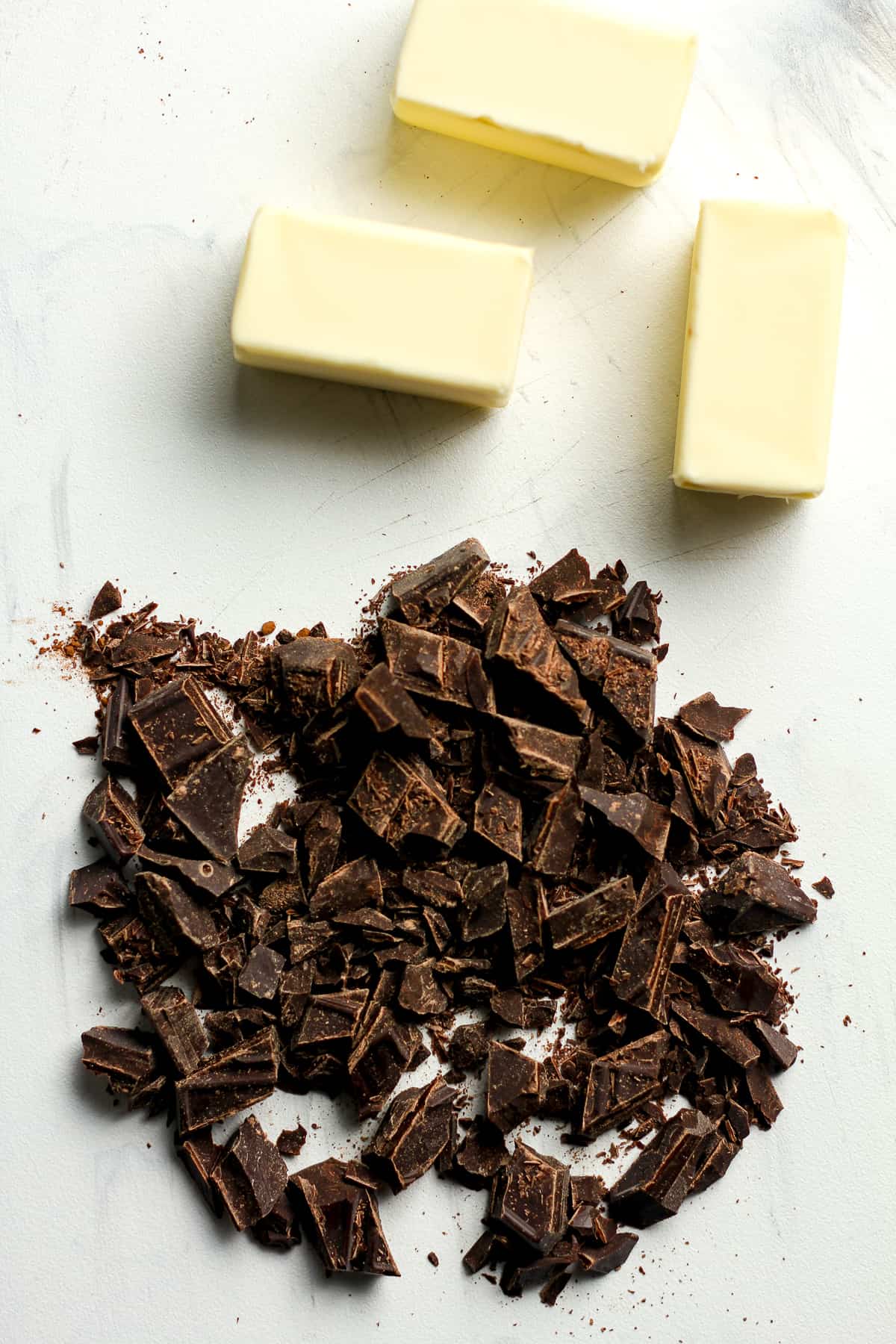 Butter and chopped chocolate bar on a board.