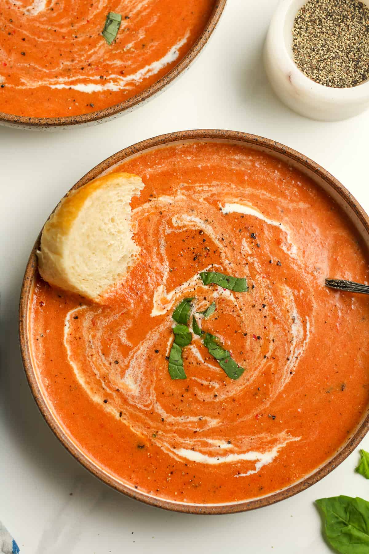 Closeup shot on a bowl of tomato bisque, with fresh basil.
