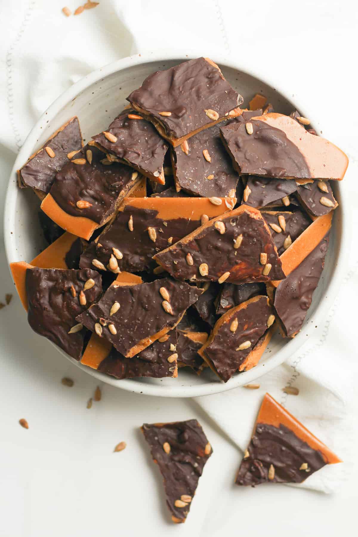 Overhead shot of a large bowl of dark chocolate toffee.