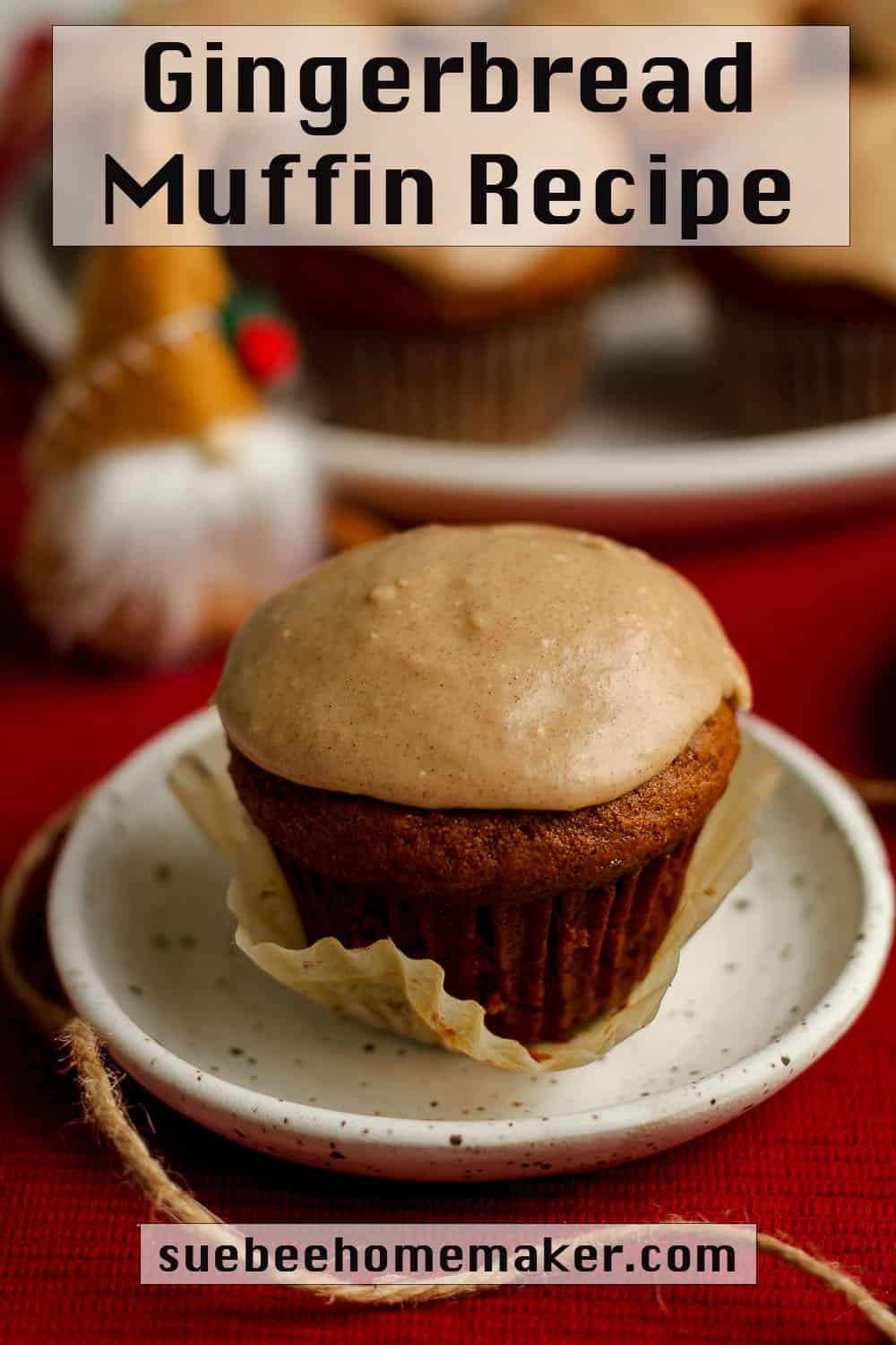 A small plate with a gingerbread muffin, with other muffins on a plate in the background.