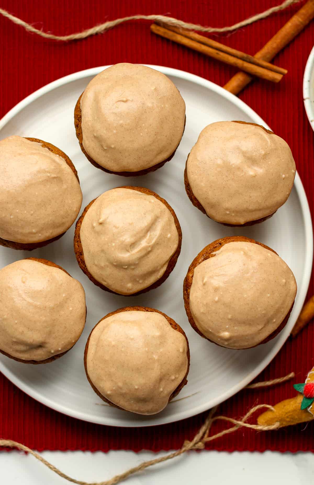 A plate of seven muffins with icing.