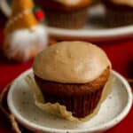 Side shot of a gingerbread muffin, with a plate of muffins in the background.