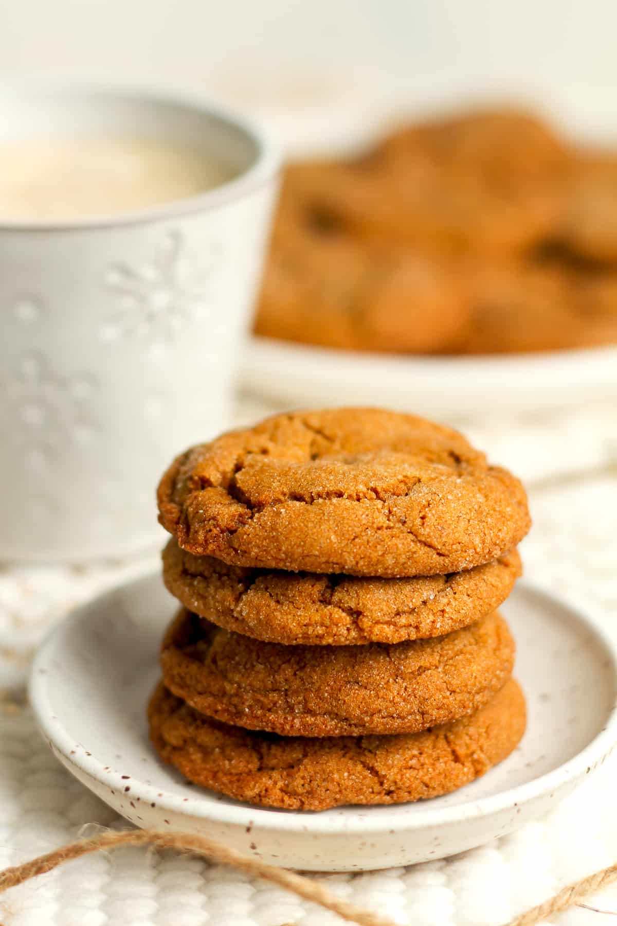 Stack of three gingersnaps with a cup of coffee.