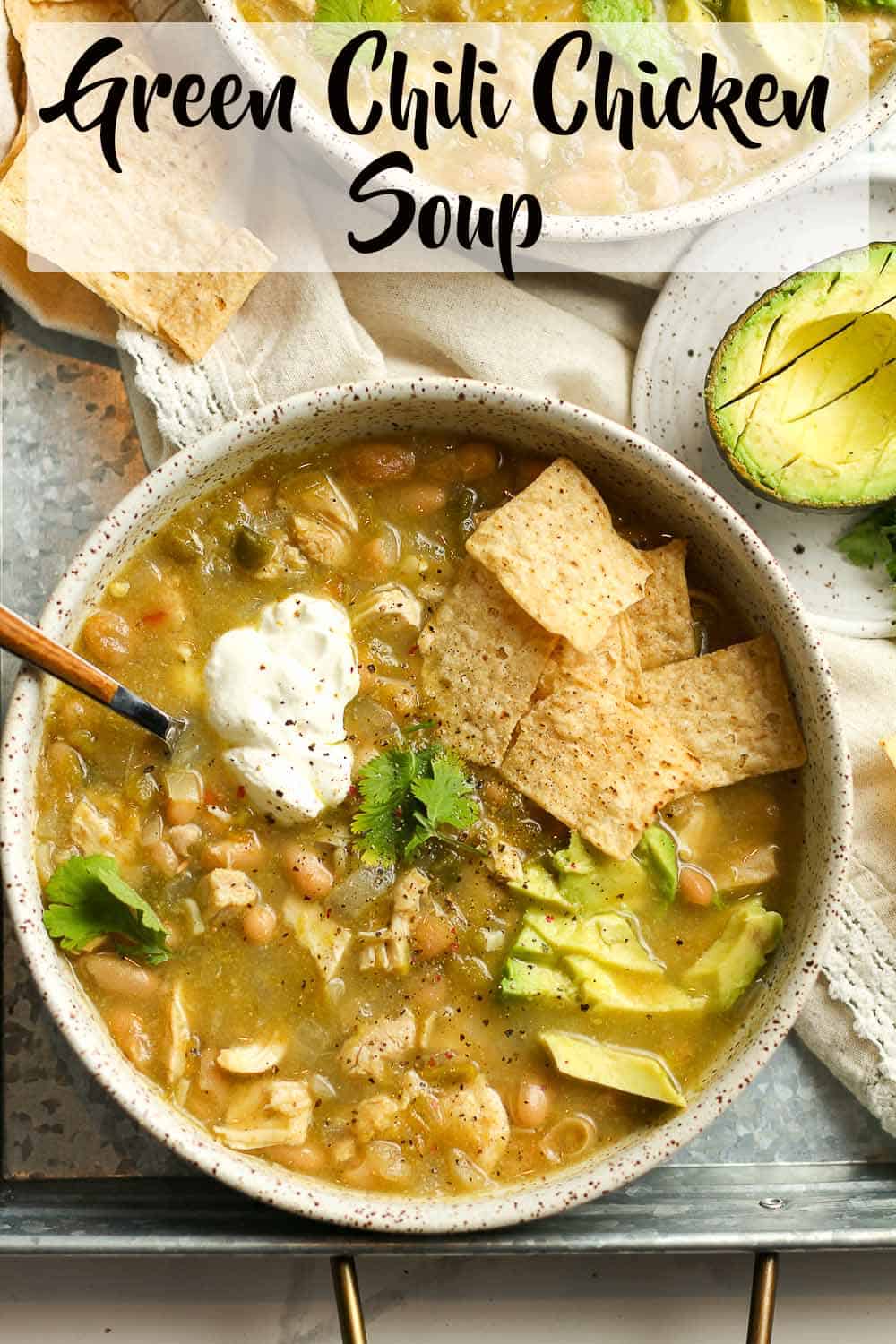 Two bowls of green chili chicken soup on a tray.