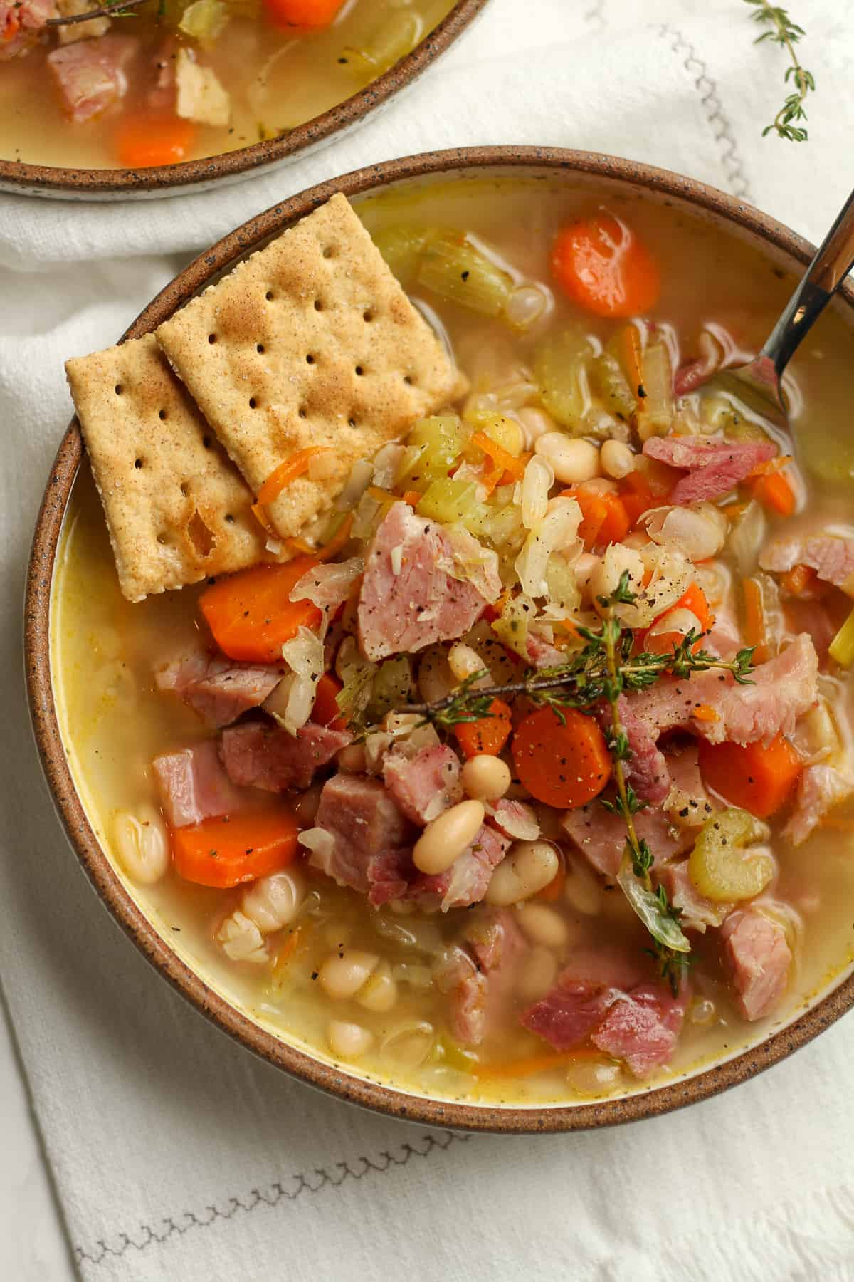 A bowl of the bean and ham soup, with crackers.