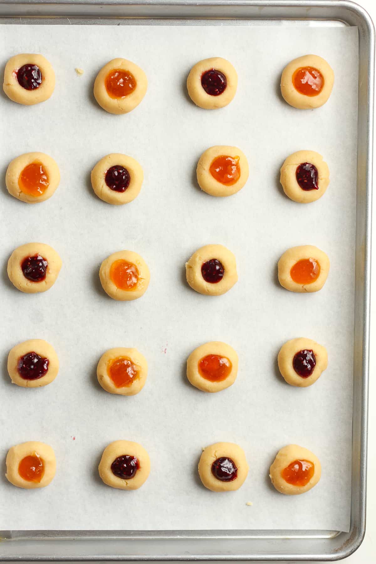 A sheet pan with the filled thumbprint shortbread cookies.
