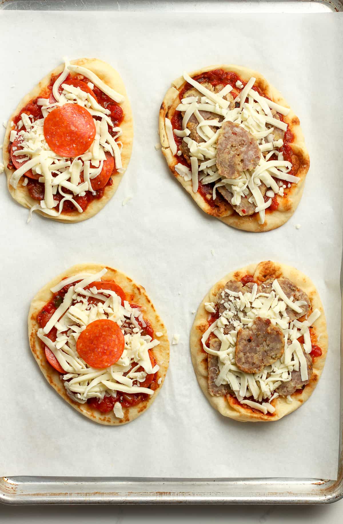 The naan bread with pizza sauce, pepperoni, sausage, and cheese.