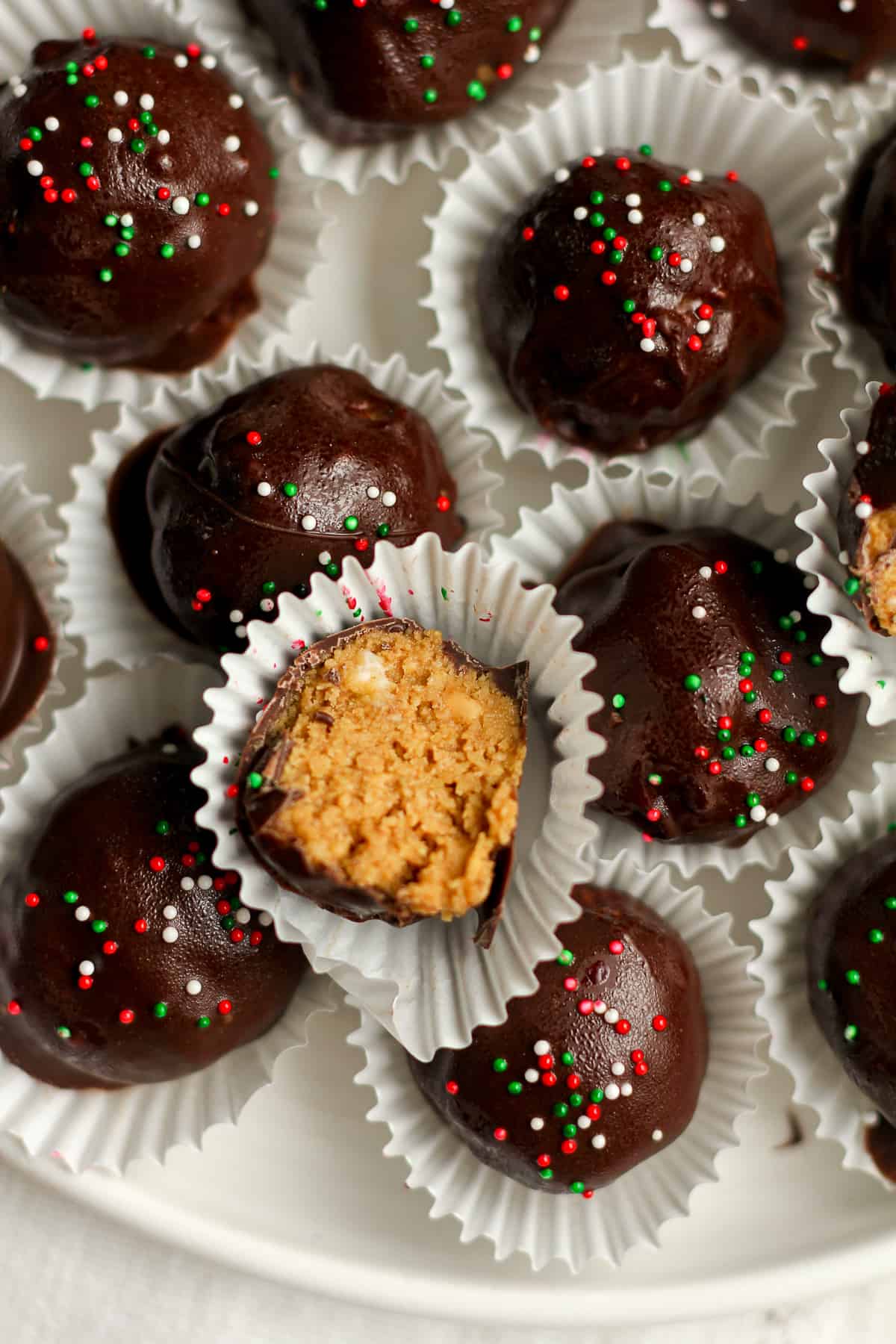Closeup on some no bake peanut butter balls with a half of a peanut butter ball.