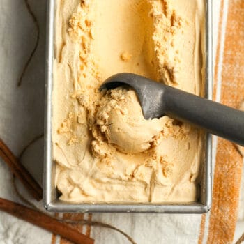 A pan of pumpkin ice cream with an ice cream scoop.