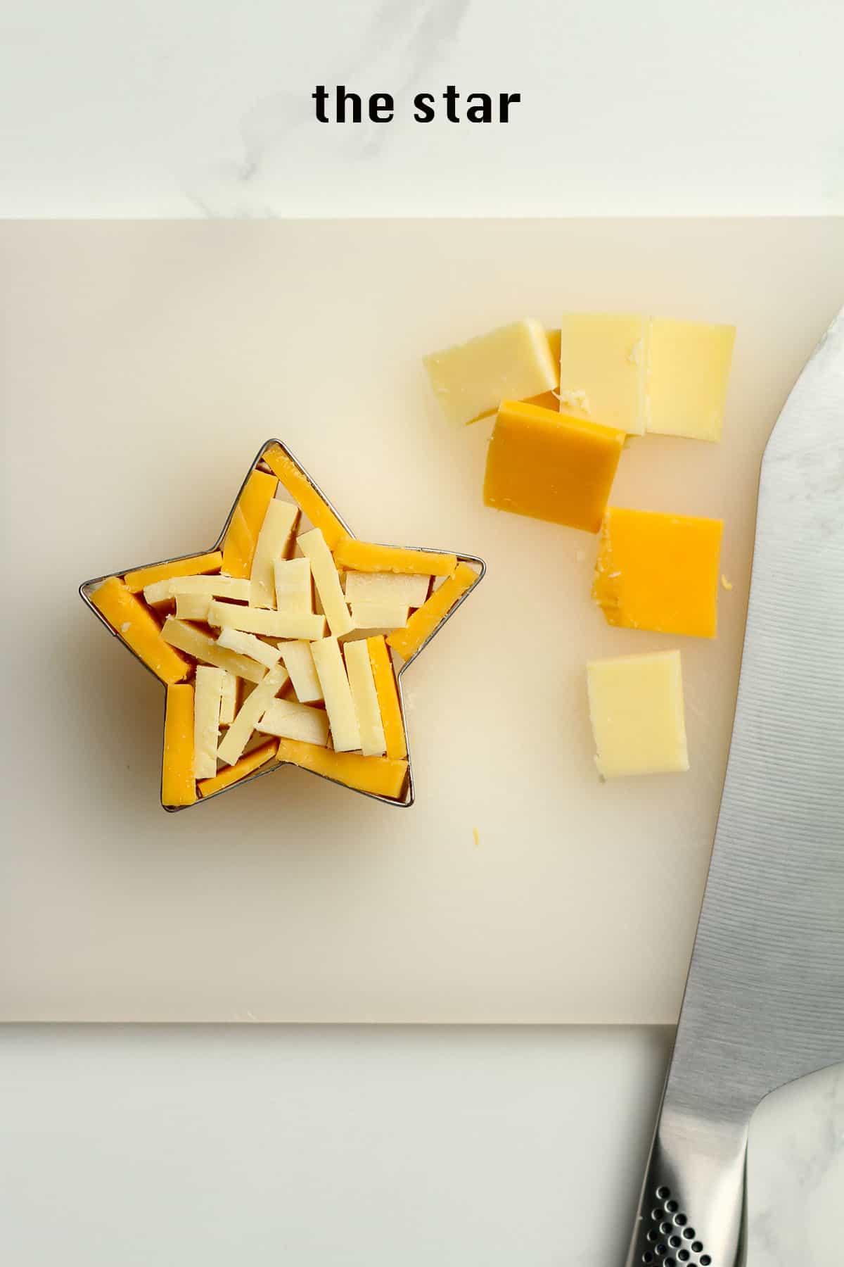 A cutting board with a cut-out star filled with sliced cheese.