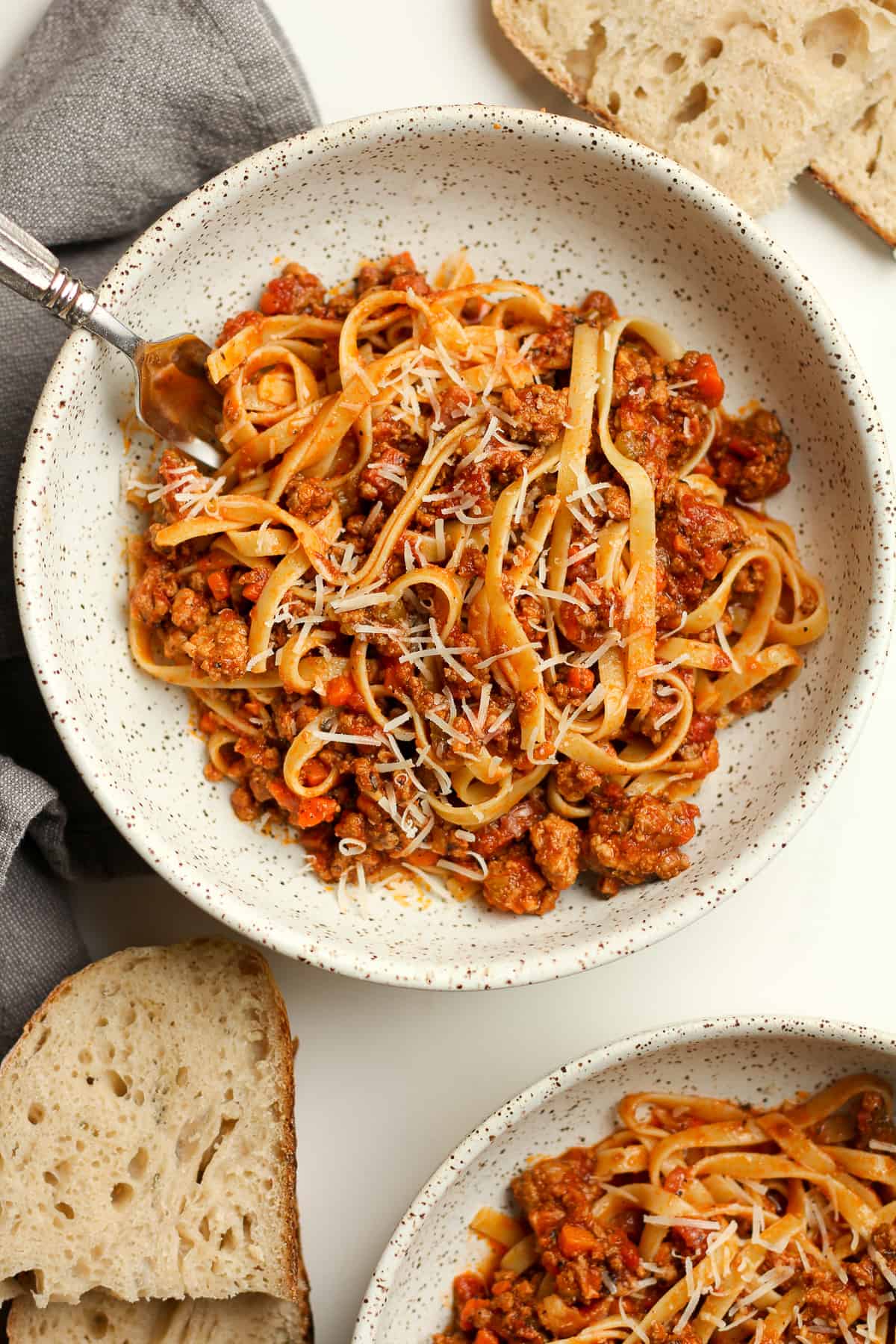 Two bowls of fettuccini with bolognese sauce.