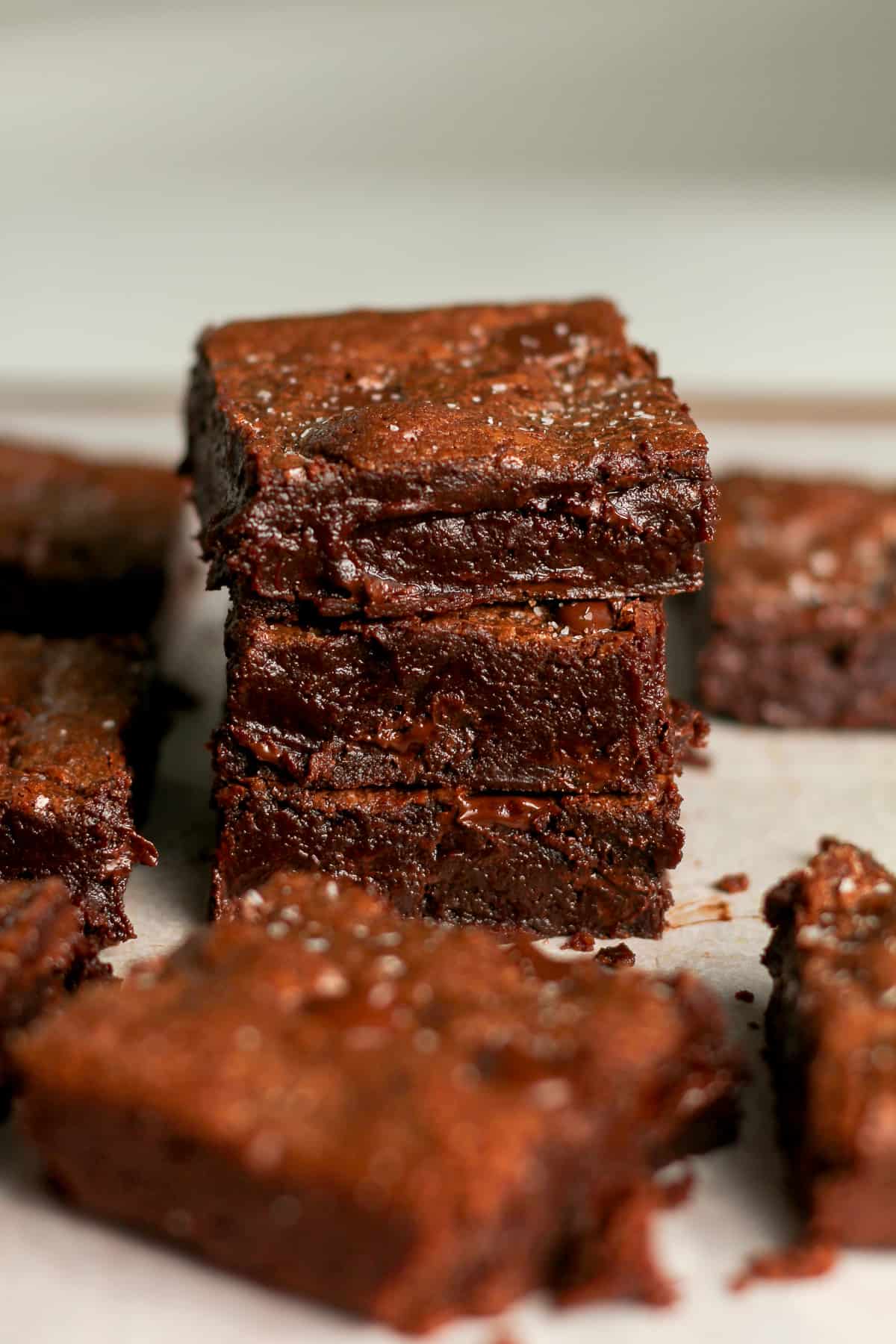 Three stacked chocolate brownies, with salt on top.