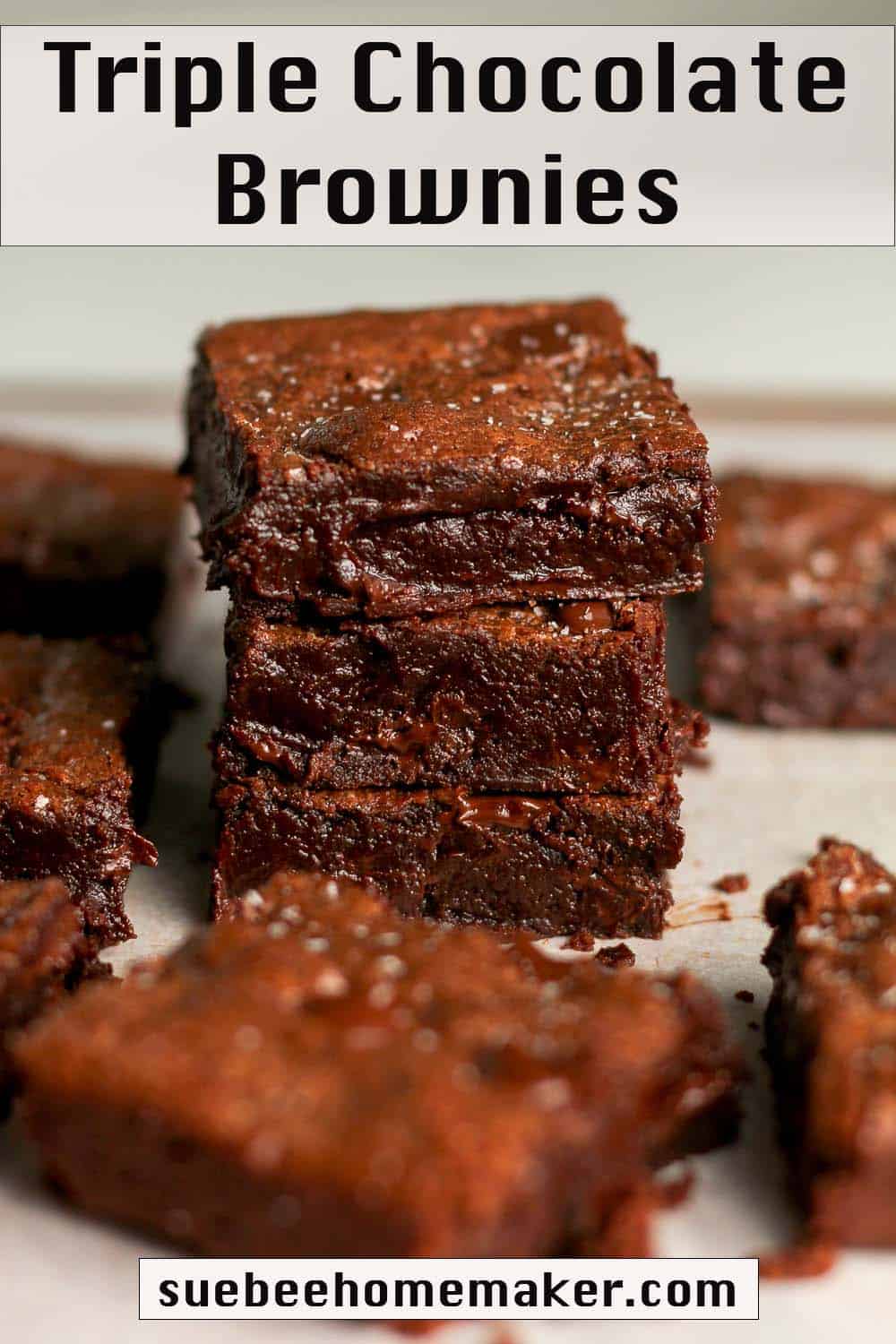 A stack of three chocolate brownies, with others surrounding.